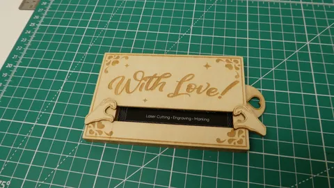 Custom wooden business card case opening to reveal laser marked black corporate card.