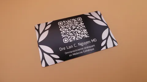 Fiber laser etching a high-contrast QR code on a black anodized aluminum smart business card.