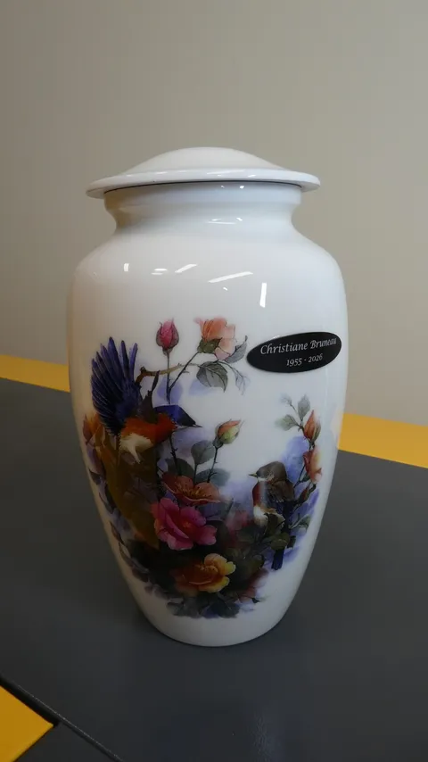 Custom personalized ceramic cremation urn with bird illustrations and a fiber laser engraved metal nameplate.
