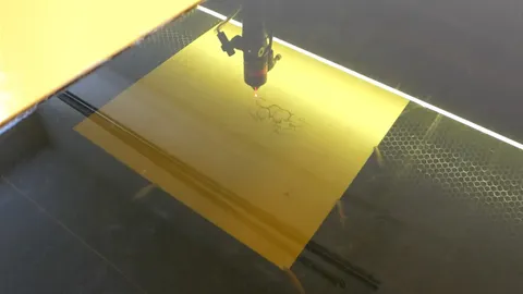 CO2 laser cutting machine scoring a flexible living hinge into a custom wooden birthday gift card envelope.