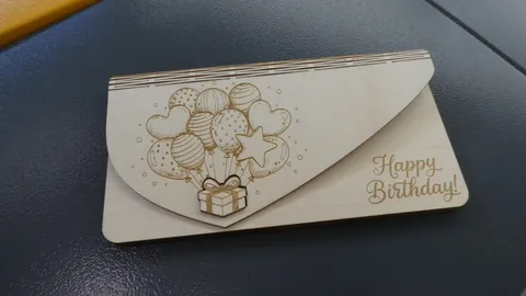 Custom laser cut wooden envelope featuring engraved birthday balloons and a matching gift box shaped lock clasp.