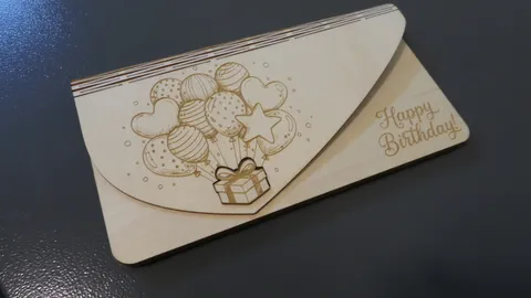 Laser engraved birch wood envelope with detailed balloon graphics and fine happy birthday cursive lettering.