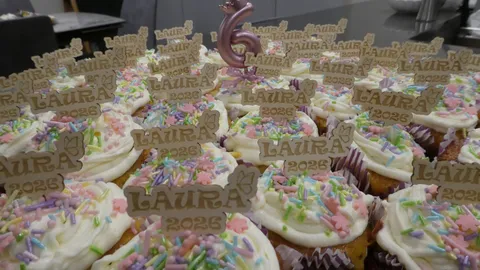 Personalized laser-engraved wooden cake topper reading La Multi Ani Laura with three detailed character faces.