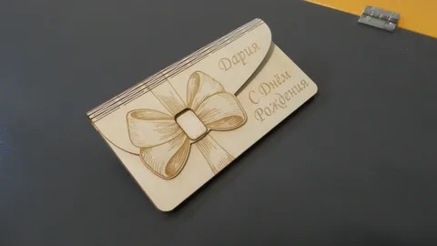 Laser engraved wooden gift envelope with personalized text and detailed ribbon bow illustration.