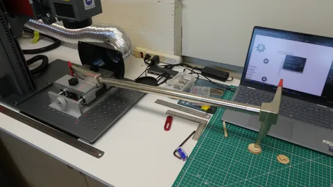 Fiber laser engraving machine aligning a steel bar horizontally using red laser guide crosshairs.